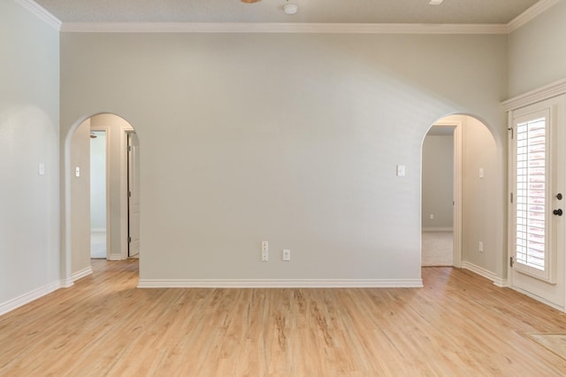 empty room with ornamental molding and light wood-type flooring