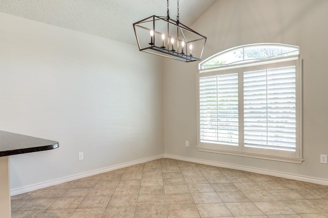 unfurnished dining area with a notable chandelier, vaulted ceiling, a textured ceiling, and light tile patterned flooring