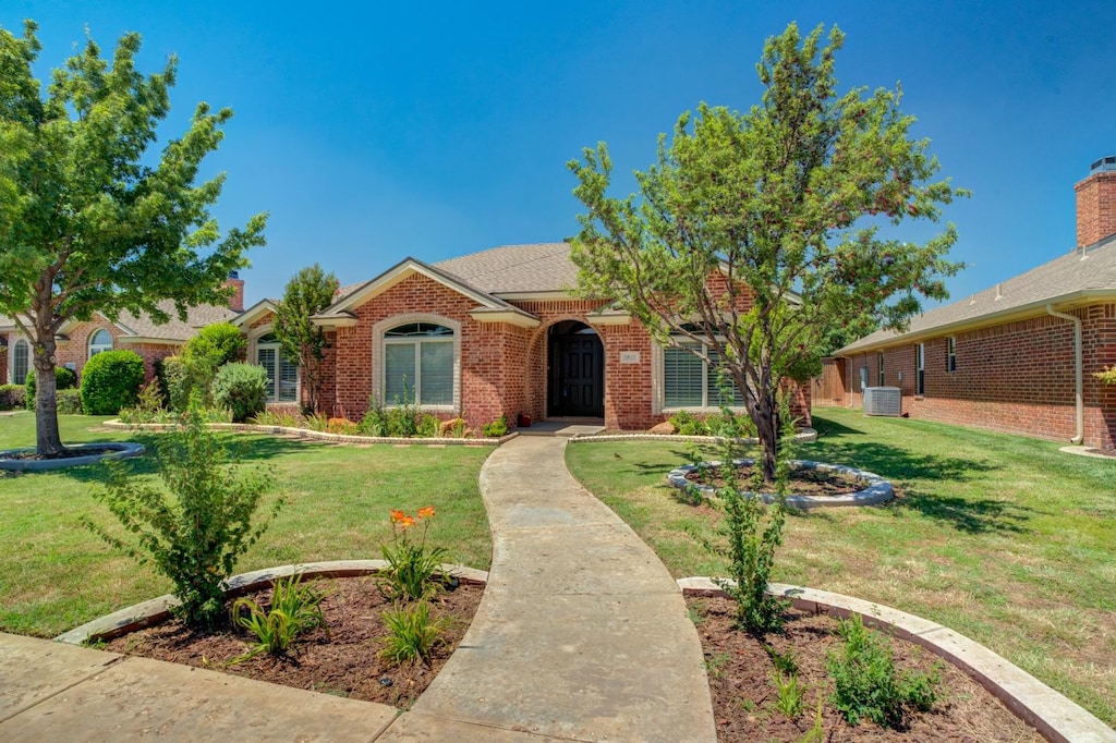 single story home featuring central AC unit and a front lawn