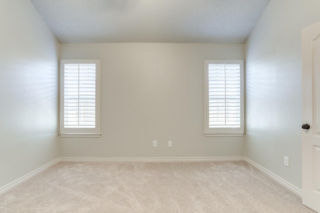 unfurnished room with light carpet and a textured ceiling