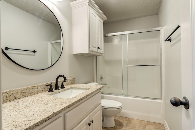 full bathroom with tile patterned floors, toilet, shower / bath combination with glass door, a textured ceiling, and vanity