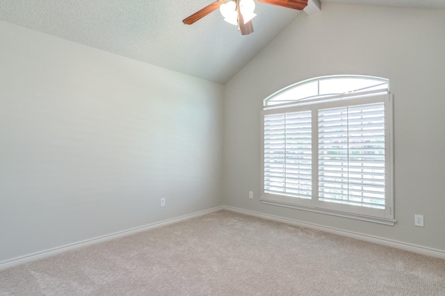 spare room with ceiling fan, vaulted ceiling, and light carpet