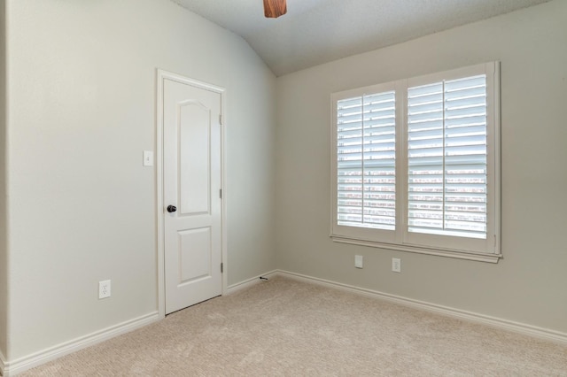 unfurnished room with light carpet, vaulted ceiling, and ceiling fan