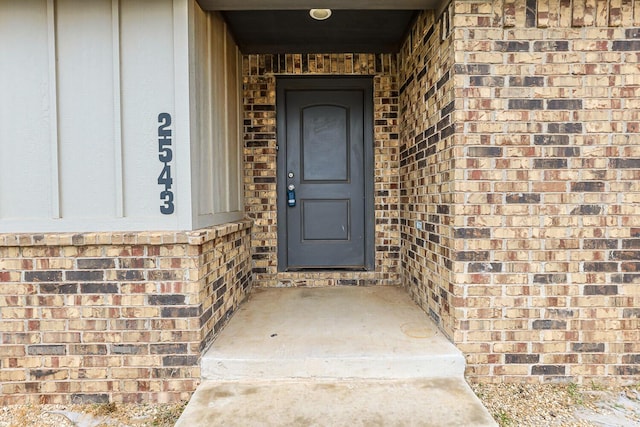 entrance to property featuring brick siding