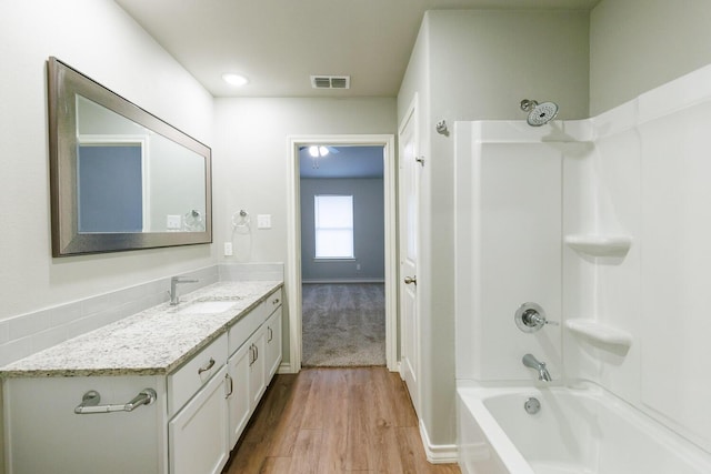 full bath with shower / tub combination, visible vents, wood finished floors, and vanity