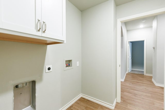 washroom with hookup for an electric dryer, washer hookup, baseboards, cabinet space, and light wood finished floors