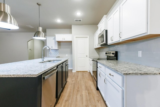 kitchen with a sink, visible vents, white cabinetry, appliances with stainless steel finishes, and light wood finished floors