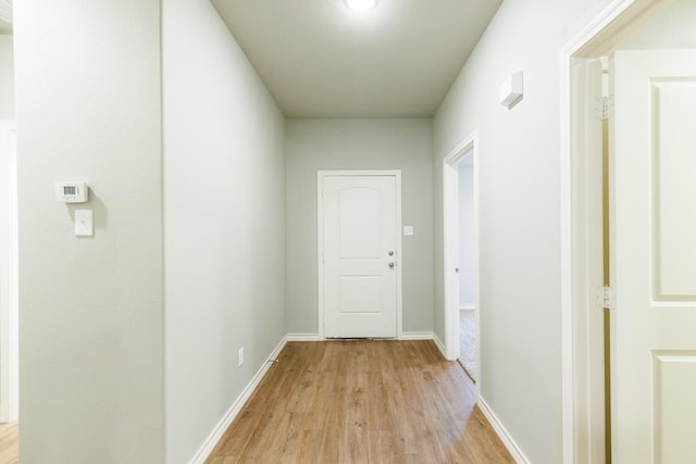 hallway with light wood-style flooring and baseboards