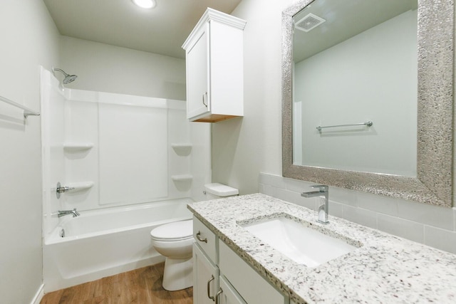 full bath featuring bathing tub / shower combination, visible vents, toilet, vanity, and wood finished floors