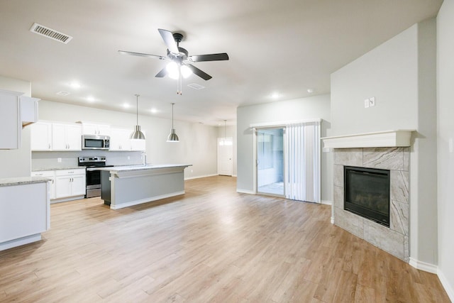 kitchen with light wood finished floors, light countertops, visible vents, appliances with stainless steel finishes, and open floor plan