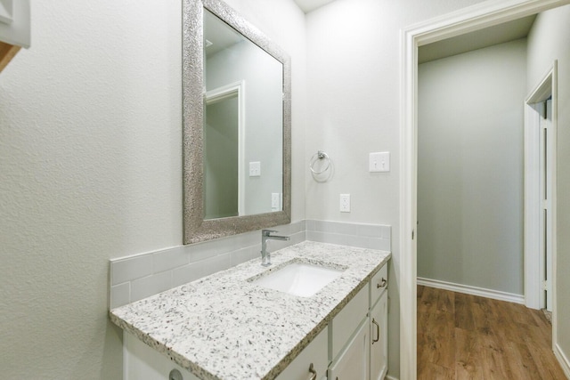 bathroom with wood finished floors, vanity, and baseboards