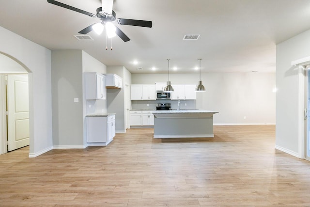 kitchen featuring appliances with stainless steel finishes, light wood-type flooring, visible vents, and white cabinetry