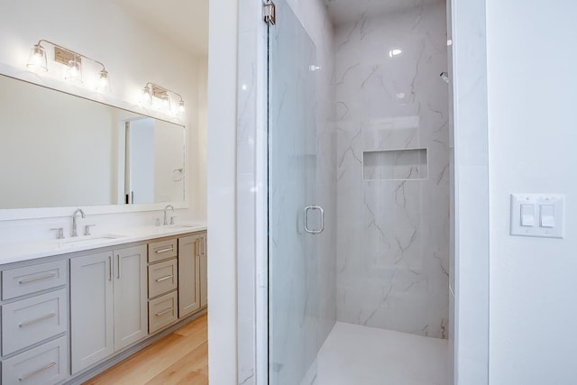 bathroom featuring walk in shower, vanity, and hardwood / wood-style flooring