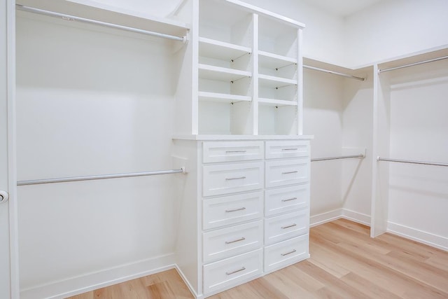 walk in closet with light hardwood / wood-style floors