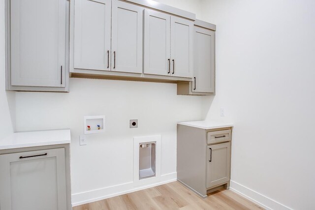 laundry room with cabinets, hookup for an electric dryer, washer hookup, and light hardwood / wood-style floors