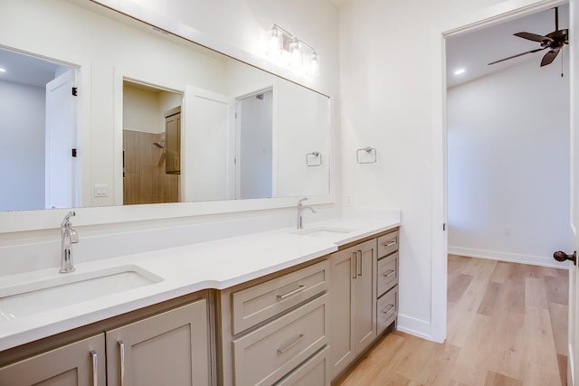 bathroom with ceiling fan, vanity, hardwood / wood-style floors, and a shower