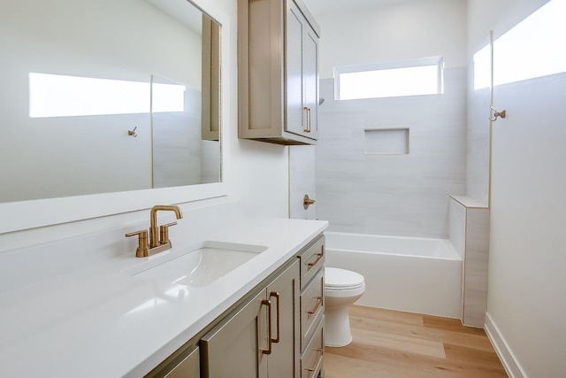 full bathroom featuring tiled shower / bath combo, vanity, hardwood / wood-style floors, and toilet