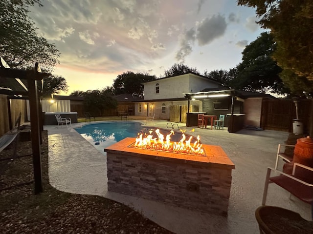 pool at dusk featuring a patio, a pergola, a bar, and an outdoor fire pit