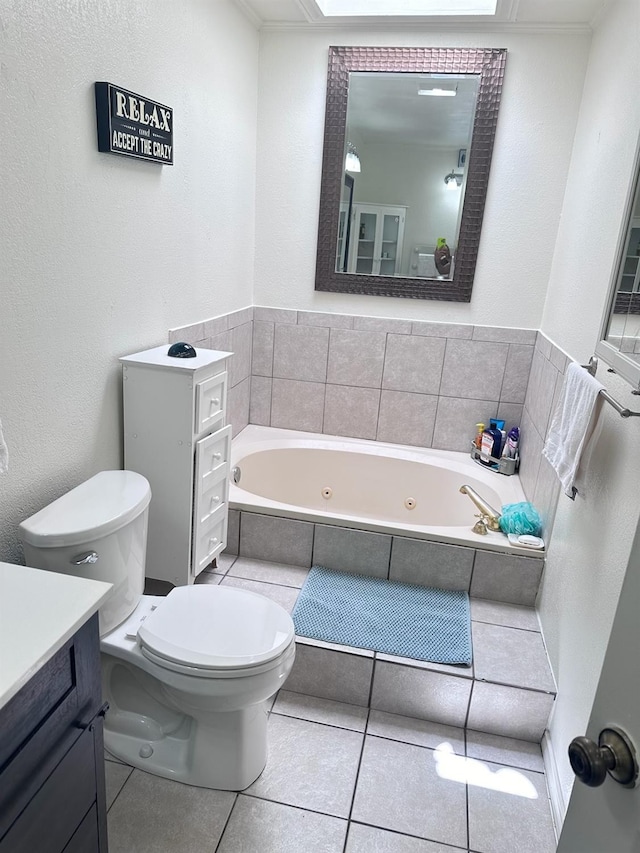 bathroom with vanity, tile patterned flooring, tiled bath, and toilet