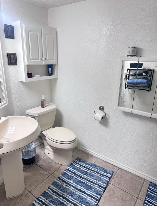 bathroom with tile patterned floors, a textured ceiling, and toilet