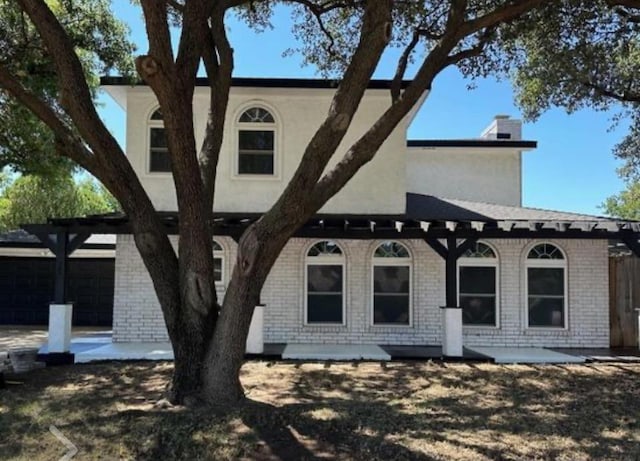 view of front of property with a garage and a patio