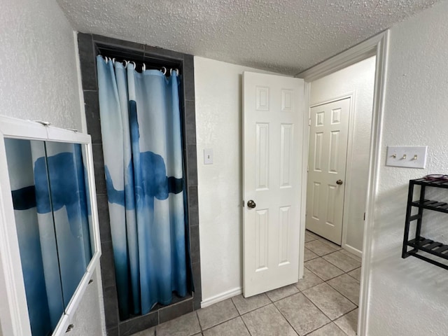 bathroom featuring tile patterned floors and a textured ceiling