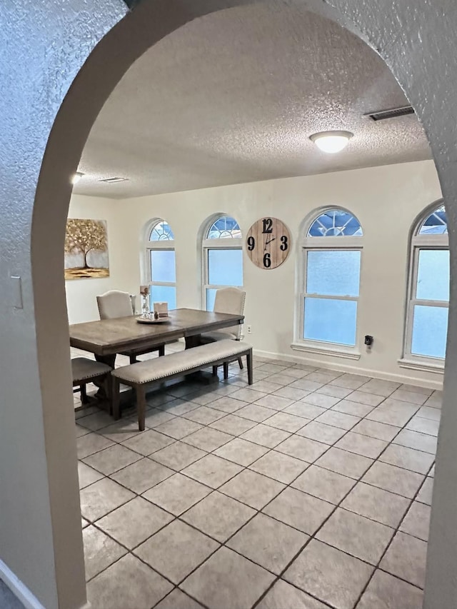 dining area featuring light tile patterned flooring and a textured ceiling