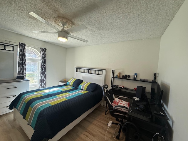 bedroom featuring a textured ceiling, ceiling fan, and light hardwood / wood-style flooring