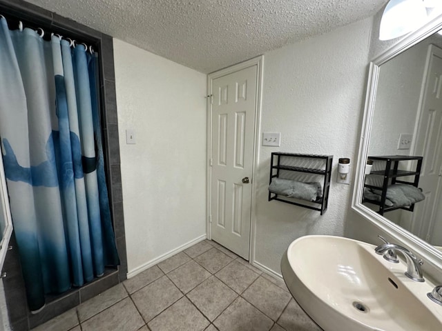 bathroom featuring sink, tile patterned floors, and a textured ceiling