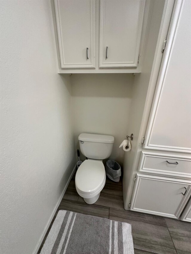 bathroom with hardwood / wood-style flooring and toilet