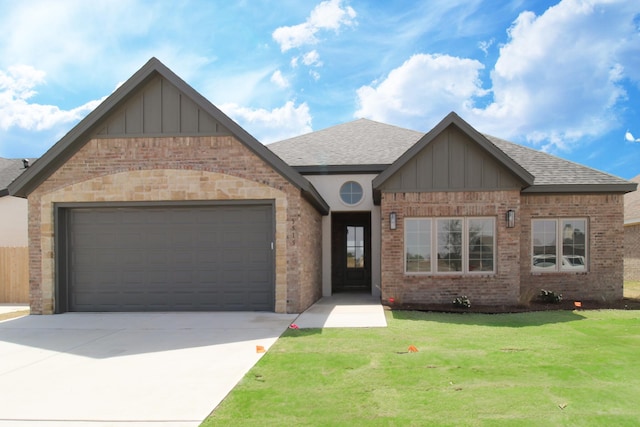 view of front of property featuring a front lawn, board and batten siding, an attached garage, driveway, and brick siding