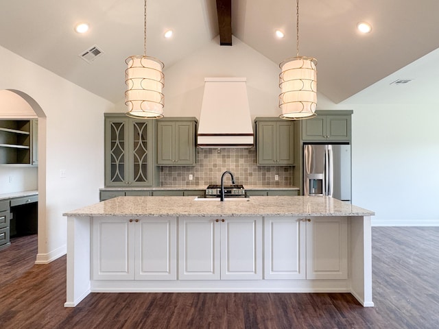kitchen featuring stainless steel appliances, visible vents, an island with sink, and custom range hood