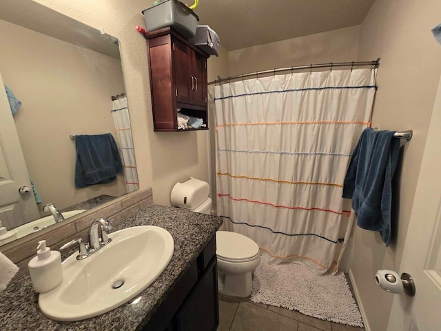 bathroom with a shower with curtain, vanity, toilet, and tile patterned flooring