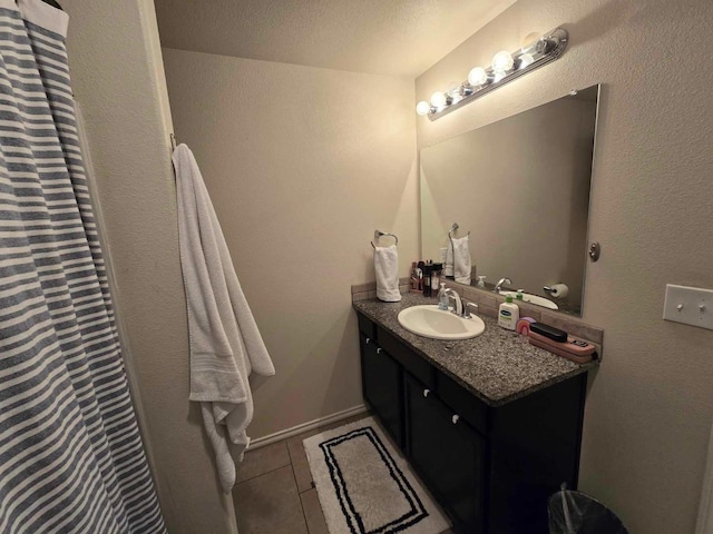 bathroom featuring tile patterned flooring, vanity, and a textured ceiling