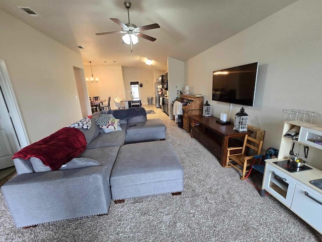 living room featuring lofted ceiling, carpet flooring, and ceiling fan with notable chandelier