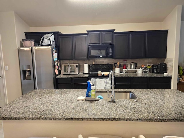 kitchen with light stone counters, sink, backsplash, and black appliances