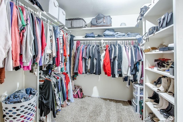 walk in closet featuring light carpet