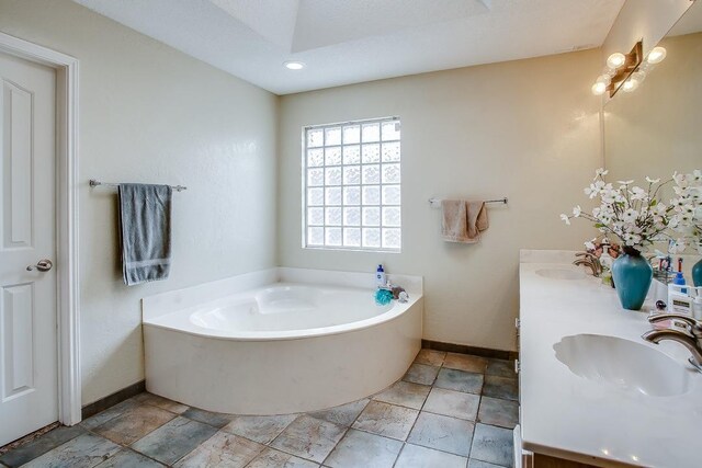 bathroom with vanity and a bath