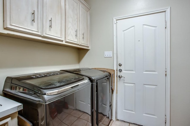 laundry room featuring cabinets, light tile patterned floors, and independent washer and dryer