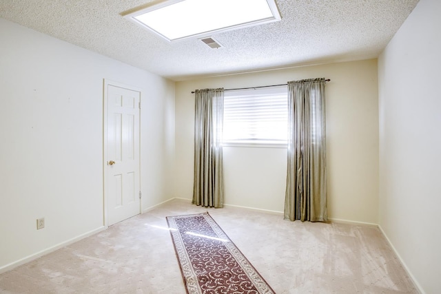 empty room featuring light carpet and a textured ceiling