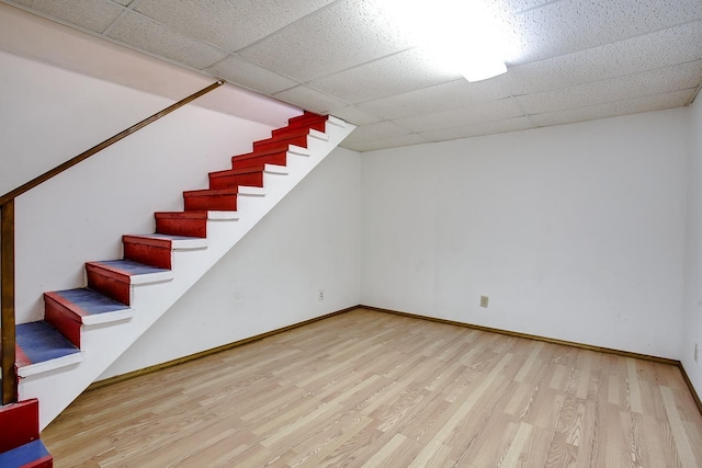 basement featuring light hardwood / wood-style flooring and a drop ceiling