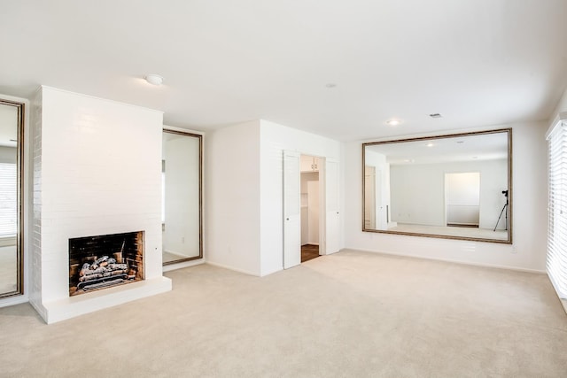 unfurnished living room featuring light carpet and a fireplace