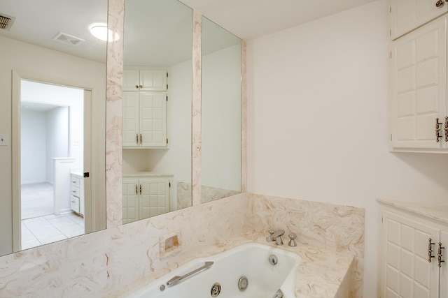 bathroom with tile patterned floors and a tub to relax in