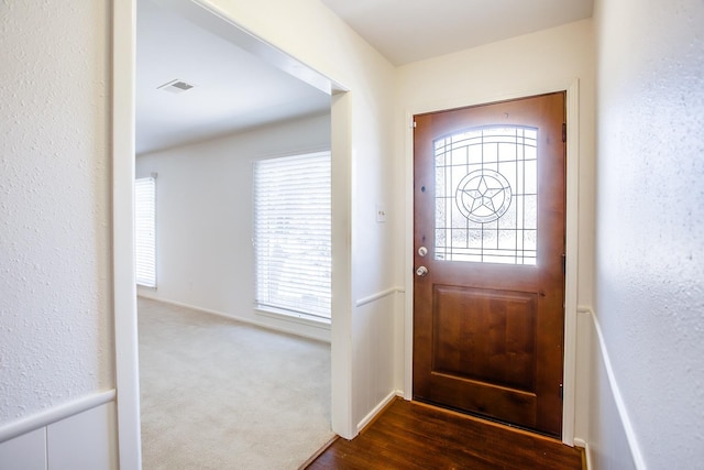 doorway with a wealth of natural light and dark carpet