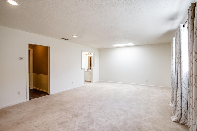 carpeted spare room with a textured ceiling