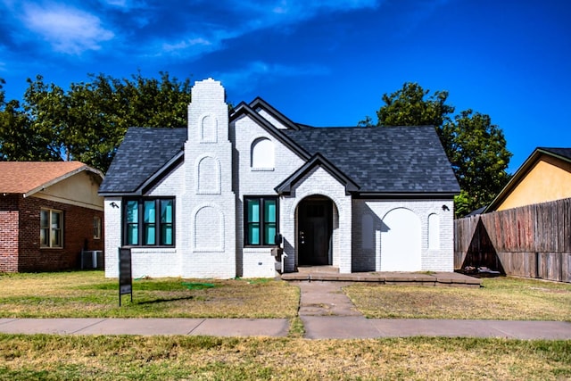 view of front facade featuring central AC and a front yard