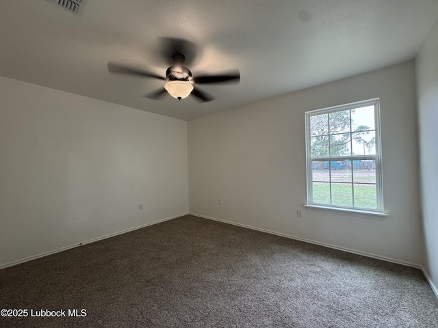 440 W Scott St, Slaton, TX 79364 - empty room with dark carpet, a ceiling fan, and baseboards