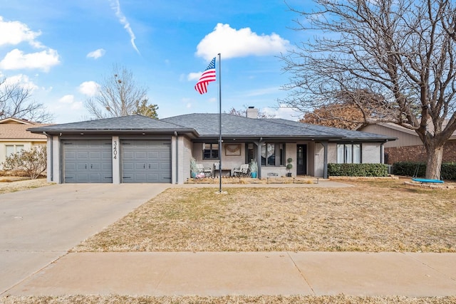 ranch-style home featuring a garage, covered porch, and a front lawn