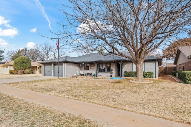 single story home featuring a porch, a garage, and a front lawn