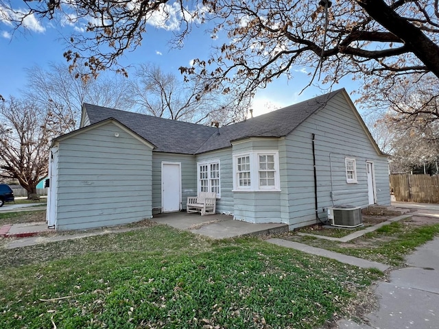 rear view of house with a patio, a yard, and central AC